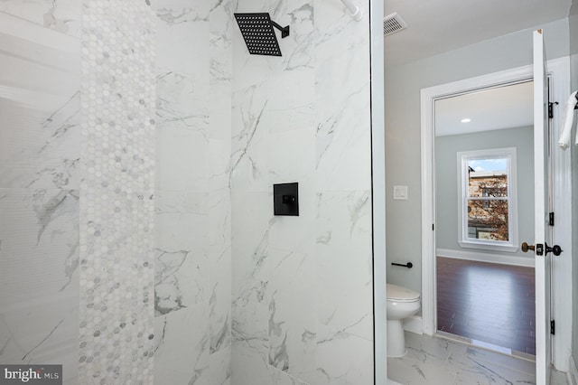 bathroom featuring toilet and a tile shower