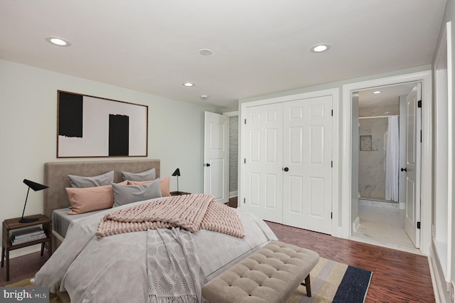 bedroom with a closet, connected bathroom, and dark hardwood / wood-style floors