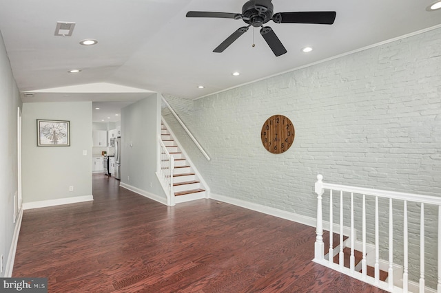 interior space featuring vaulted ceiling, ceiling fan, brick wall, and wood-type flooring