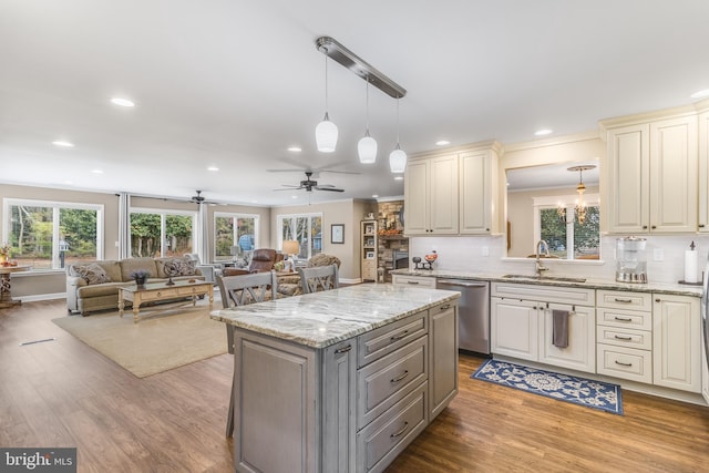 kitchen featuring ceiling fan, dishwasher, sink, light hardwood / wood-style floors, and decorative light fixtures