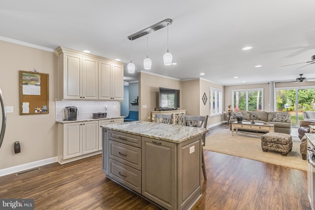 kitchen with tasteful backsplash, crown molding, decorative light fixtures, dark hardwood / wood-style floors, and a kitchen island