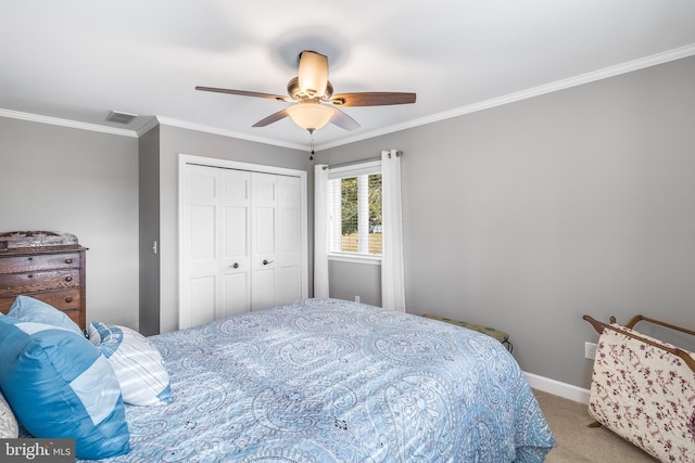 carpeted bedroom with ceiling fan, a closet, and ornamental molding