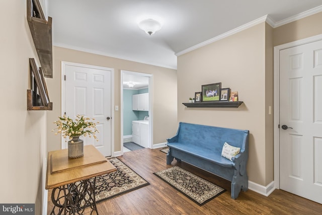 sitting room featuring ornamental molding, independent washer and dryer, and dark wood-type flooring