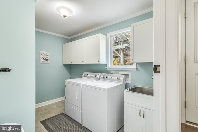 laundry room featuring washing machine and dryer, crown molding, and cabinets