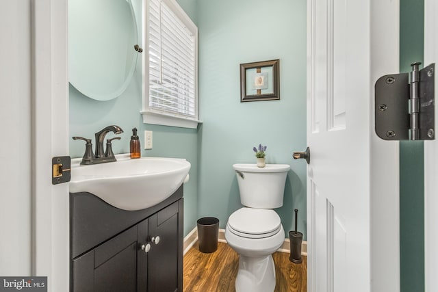 bathroom featuring toilet, vanity, and hardwood / wood-style flooring