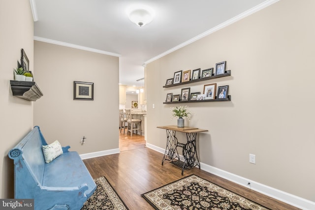 sitting room with hardwood / wood-style floors and crown molding