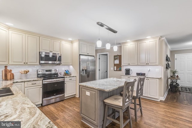 kitchen featuring tasteful backsplash, hardwood / wood-style flooring, decorative light fixtures, and appliances with stainless steel finishes