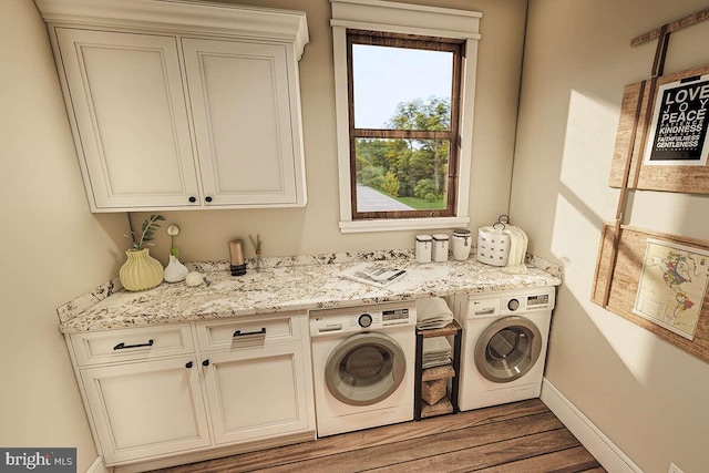 laundry room with cabinets, hardwood / wood-style flooring, and washer and dryer