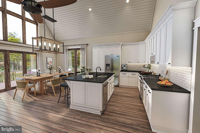 kitchen with white cabinetry, sink, dark wood-type flooring, stainless steel appliances, and a kitchen island with sink