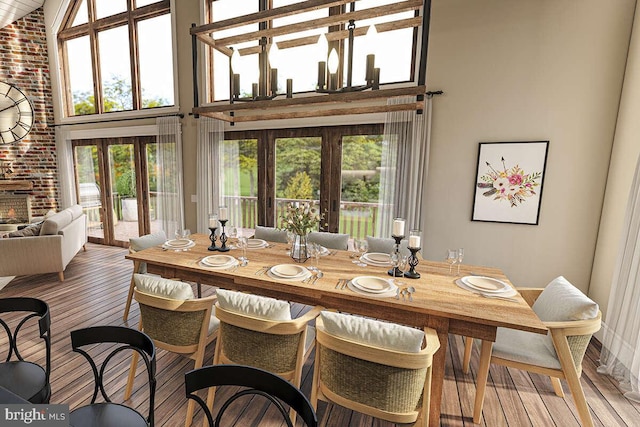 dining area with french doors, a towering ceiling, brick wall, and hardwood / wood-style flooring