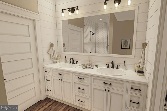 bathroom featuring wood-type flooring, vanity, and a tile shower