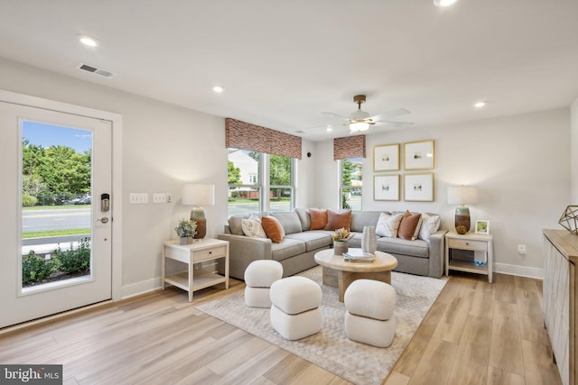 living room featuring ceiling fan, a healthy amount of sunlight, and light wood-type flooring