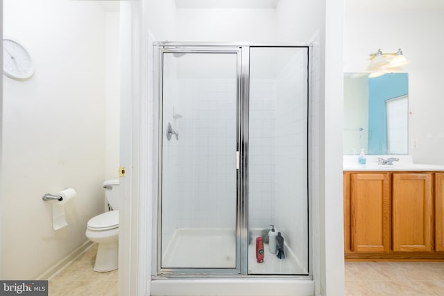 bathroom featuring tile patterned flooring, vanity, toilet, and walk in shower