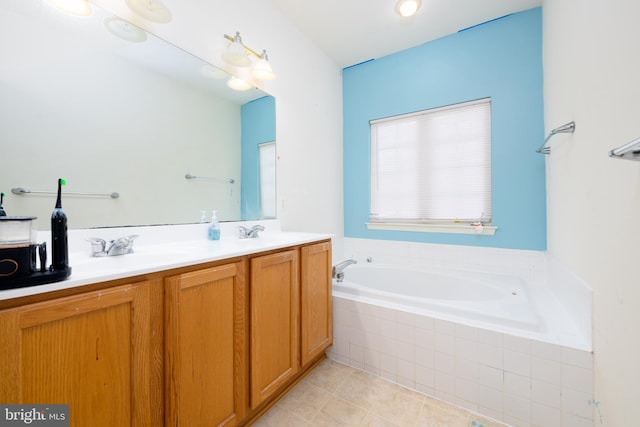 bathroom with tile patterned floors, tiled tub, and vanity