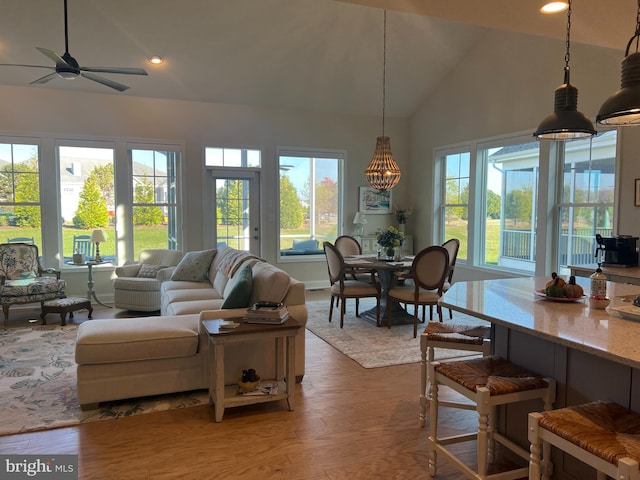 living room with hardwood / wood-style flooring, ceiling fan, and vaulted ceiling