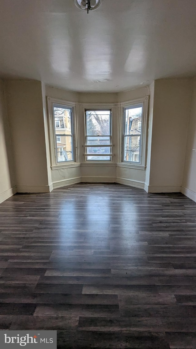 unfurnished room with dark hardwood / wood-style floors