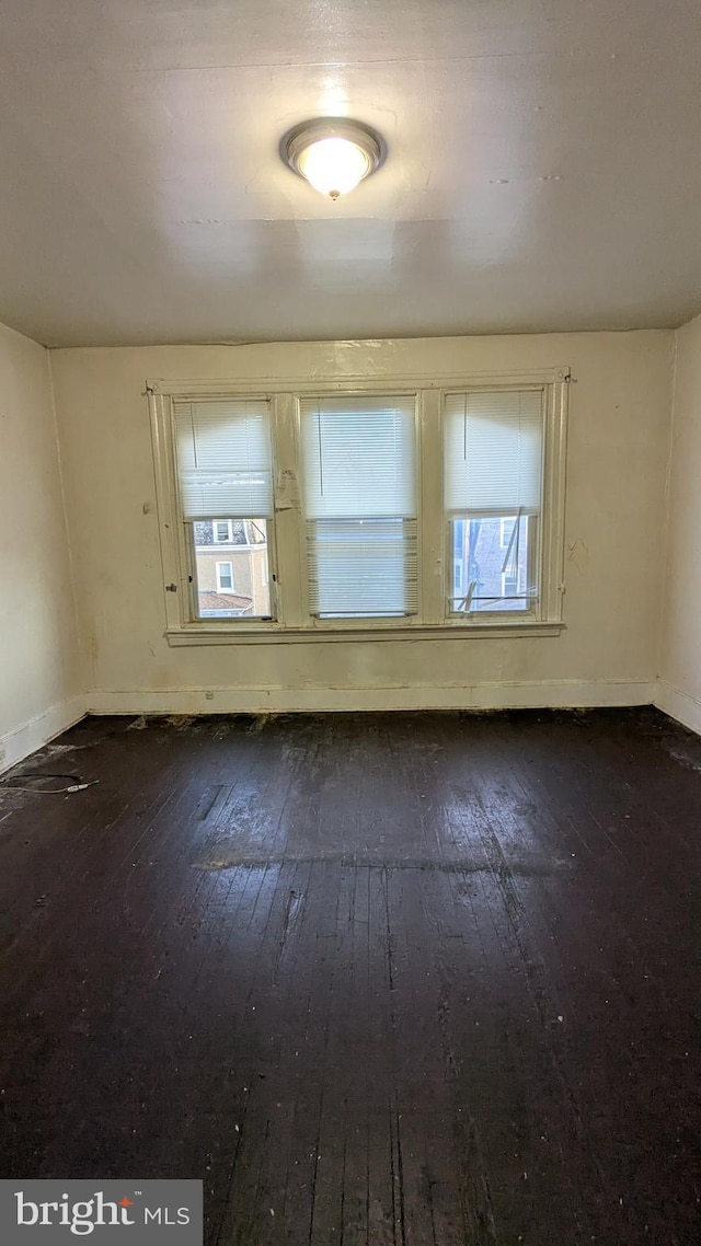 unfurnished room with dark hardwood / wood-style flooring