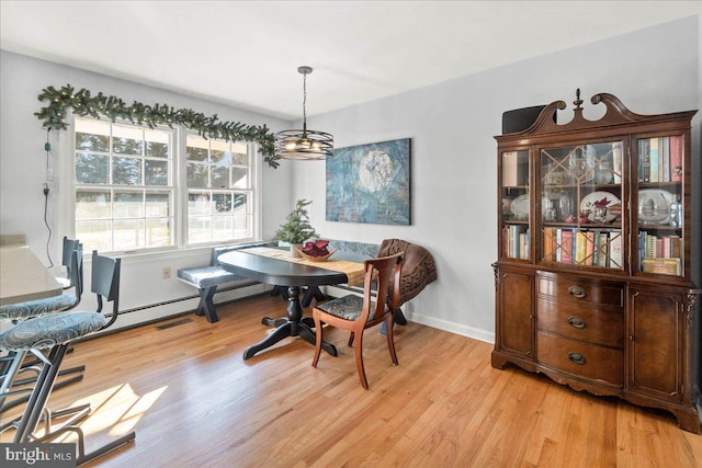 dining space with a chandelier and light hardwood / wood-style flooring