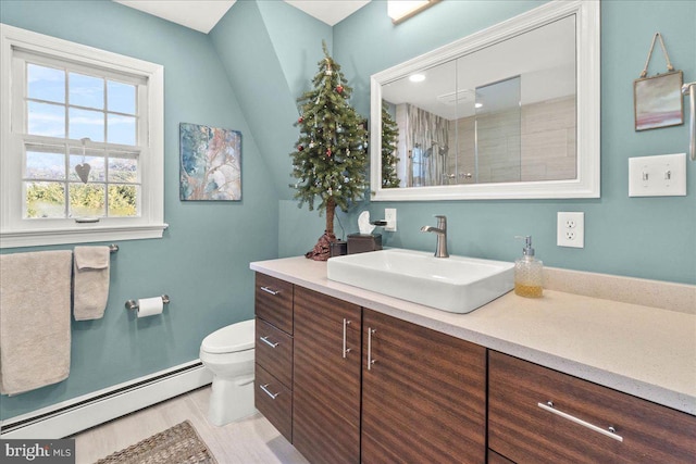 bathroom with baseboard heating, vanity, a shower with shower door, and toilet