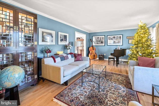 living room featuring crown molding, plenty of natural light, french doors, and light wood-type flooring