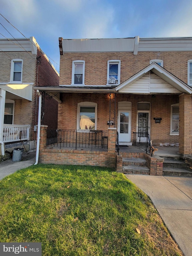 view of front of house with covered porch and a front lawn