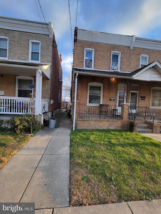 multi unit property featuring a porch and a front yard