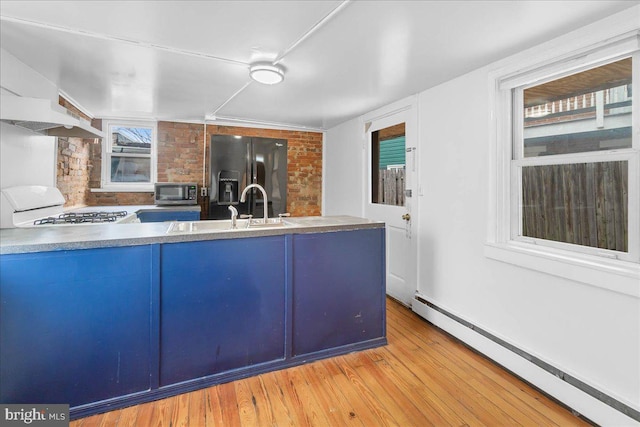 kitchen featuring black refrigerator with ice dispenser, white range, sink, baseboard heating, and light hardwood / wood-style floors