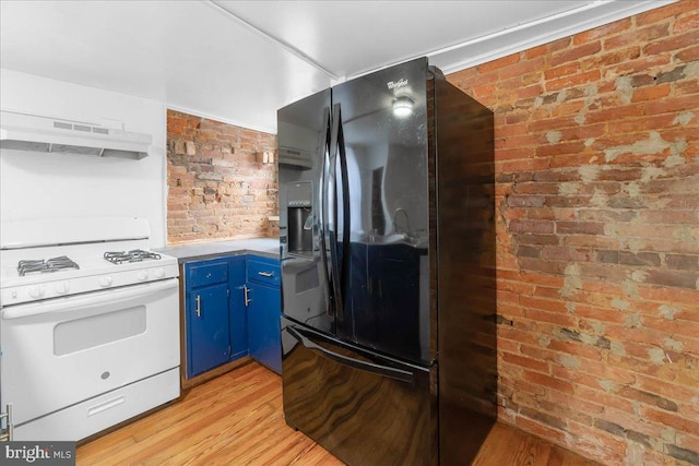 kitchen featuring blue cabinetry, black fridge, brick wall, range hood, and white stove