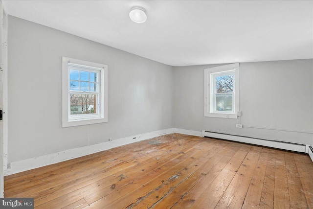 empty room with wood-type flooring and a baseboard radiator