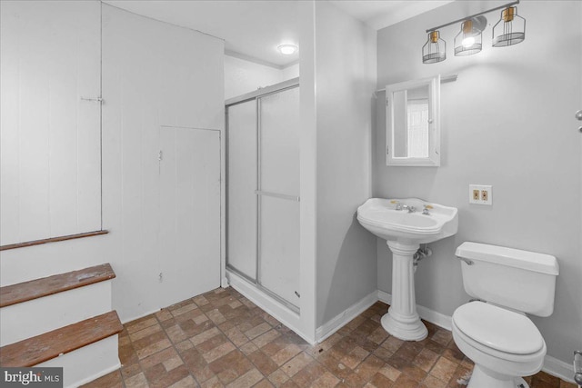 bathroom with toilet and a shower with shower door