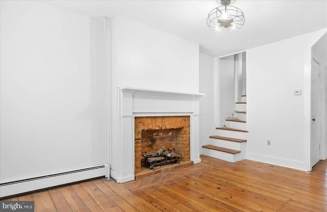 unfurnished living room featuring a fireplace, light hardwood / wood-style flooring, and baseboard heating