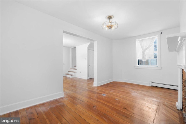 spare room with light hardwood / wood-style floors and a baseboard heating unit