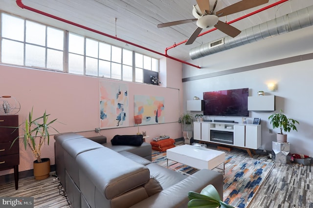 living room with a towering ceiling and ceiling fan