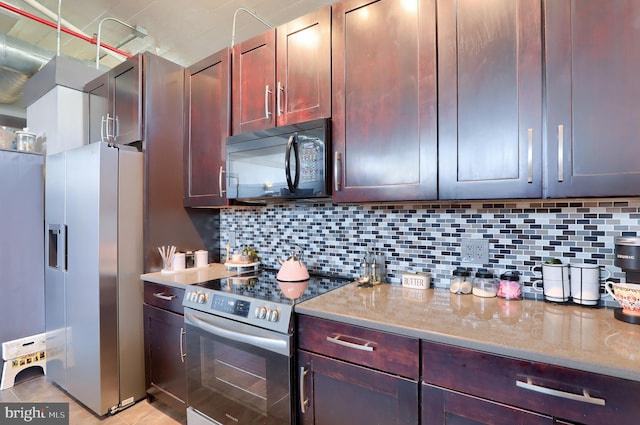 kitchen featuring tasteful backsplash, light stone countertops, and stainless steel appliances