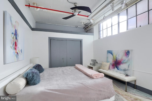 bedroom with ceiling fan, a towering ceiling, and a closet