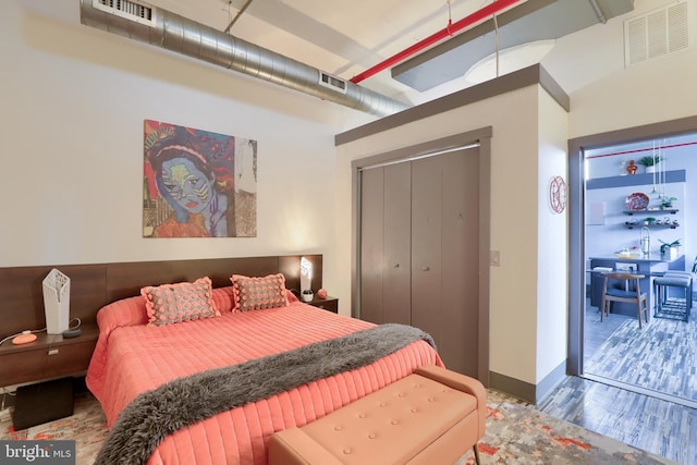 bedroom featuring wood-type flooring and a closet