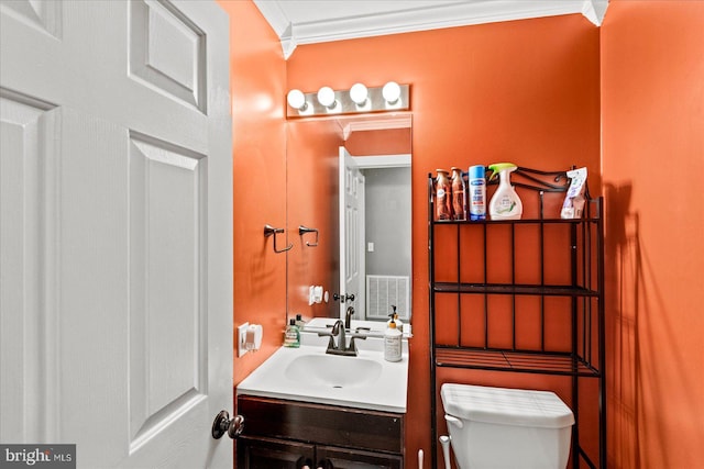 bathroom with vanity, toilet, and crown molding