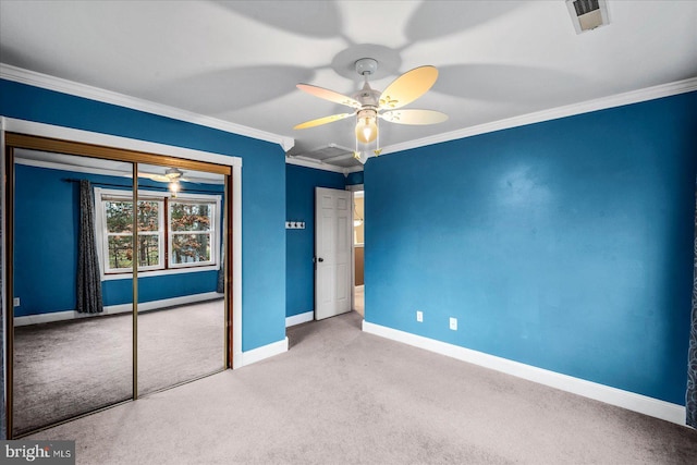 unfurnished bedroom featuring crown molding, ceiling fan, a closet, and light colored carpet