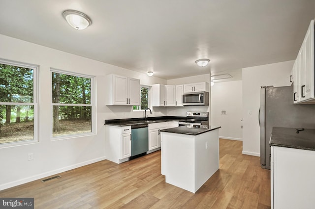 kitchen featuring white cabinets, appliances with stainless steel finishes, and plenty of natural light