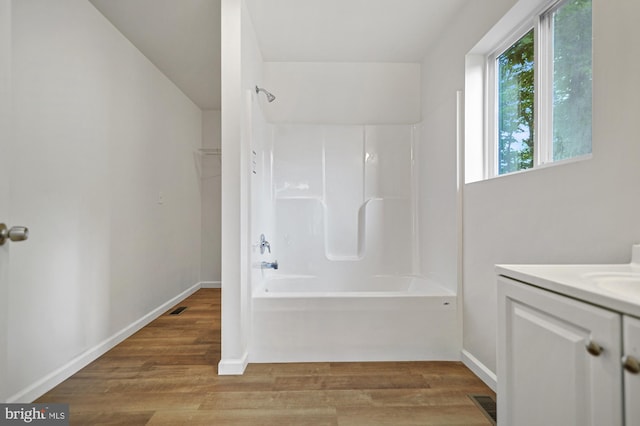 bathroom featuring bathtub / shower combination, hardwood / wood-style floors, and vanity