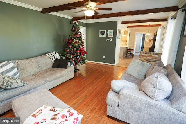 living room featuring ceiling fan, beamed ceiling, wood-type flooring, and ornamental molding