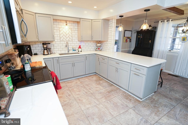 kitchen featuring gray cabinetry, electric range, sink, kitchen peninsula, and decorative light fixtures