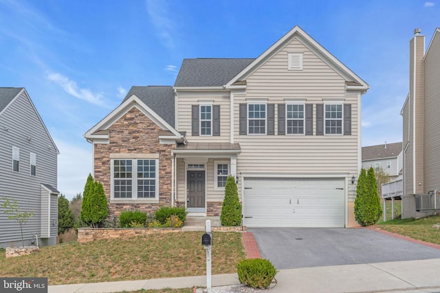 view of front of home with central AC unit and a garage