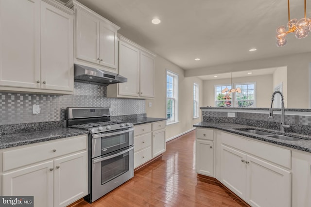 kitchen with an inviting chandelier, white cabinetry, stainless steel gas range oven, and sink