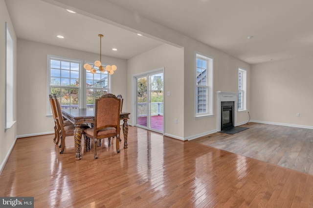 dining area with light wood-type flooring and a notable chandelier