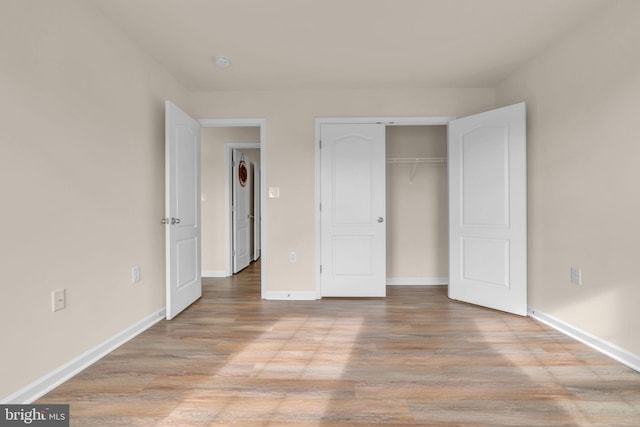 unfurnished bedroom with light wood-type flooring and a closet