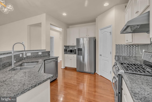 kitchen with sink, stainless steel appliances, light hardwood / wood-style flooring, decorative backsplash, and white cabinets