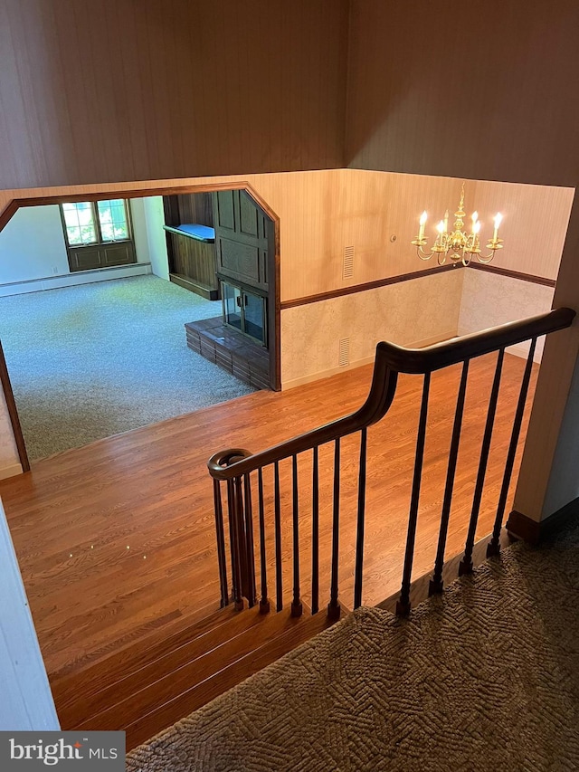 stairs featuring carpet floors and a chandelier