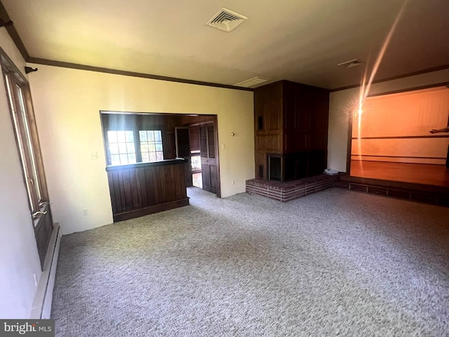 unfurnished living room featuring baseboard heating, a large fireplace, carpet, and ornamental molding