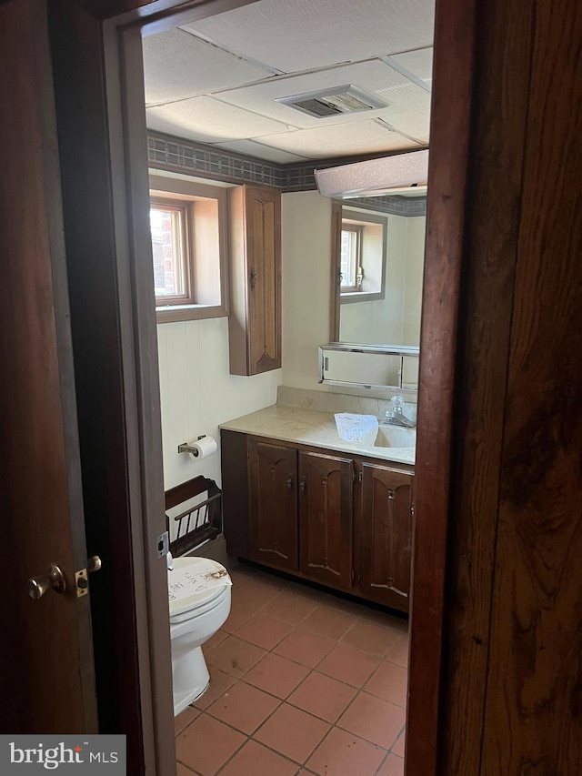 bathroom with toilet, vanity, and tile patterned floors